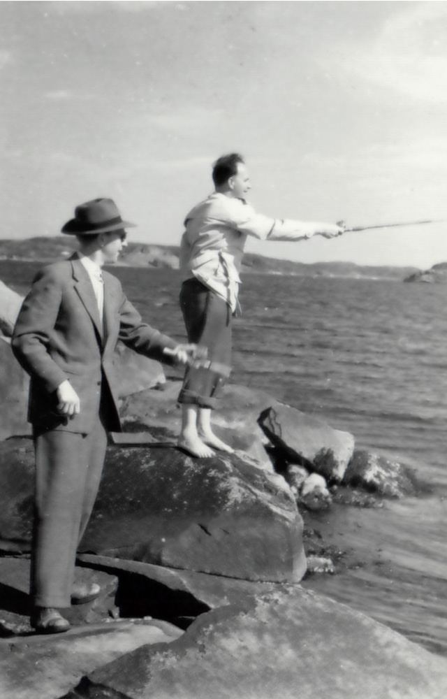 2 stycken herrar som spinnfiskar från klippor. En i kostym och hatt