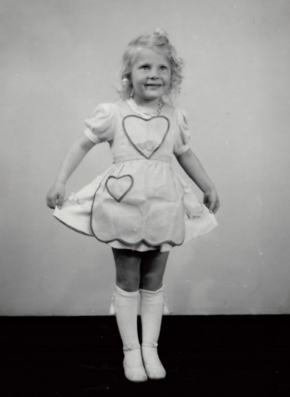 Yngre tjej ca 6 år visar upp sin klänning med två hjärtan på.
