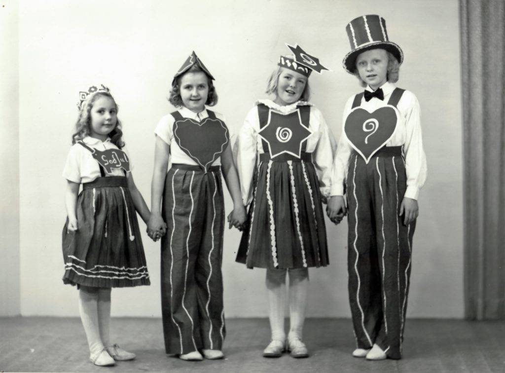 Äldre svartvitt foto föreställande 4 barn iklädda "pepparkakskläder"