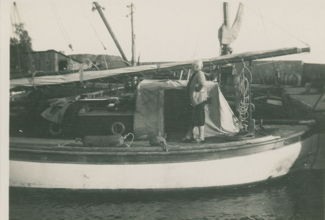Fru Rehnberg på däck på Seger II. Båten ligger vid kaj.